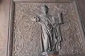 Figur mit Kirchenmodell