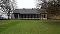 Das Hauptgebäude von der Seite des im Stile eines englischen Parks angelegten Gartens.