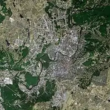 Satellitenaufnahme von Vilnius mit den bebauten Gebieten und den Grünflächen, durch die ein Fluss von links unten nach rechts oben führt.