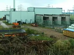 Westansicht der für die nie realisierte HGÜ-Kurzkupplung Wolmirstedt errichteten Stromrichterhalle mit erkennbaren Transformatorenbuchten; heute Bestandteil des Recylinghofs Farsleben