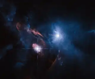 Aufnahme der von einer Molekülwolke umgebenen Sterne HL Tauri (rechts oberhalb der Mitte, bläulich) und XZ Tauri (links unterhalb der Mitte, rötlich) erstellt mit dem Hubble-Weltraumteleskop