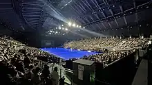 Blick über die Eisfläche und die gefüllten Zuschauertribünen der Sekisui Heim Super Arena in Rifu, Miyagi. Im Hintergrund eine Großleinwand mit dem Logo der Show.
