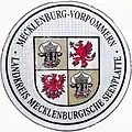 Zulassungsplakette des Landkreises Mecklenburgische Seenplatte mit dem mecklenburg-vor­pommerschen Lan­deswappen bis 2014