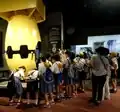 Eine japanische Schulklasse vor einem Modell von Fat Man