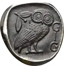 Emblem der GIG auf der Basis einer attischen Tetradrachme (ca. 430 v. Chr.) mit den Initialen der Gesellschaft